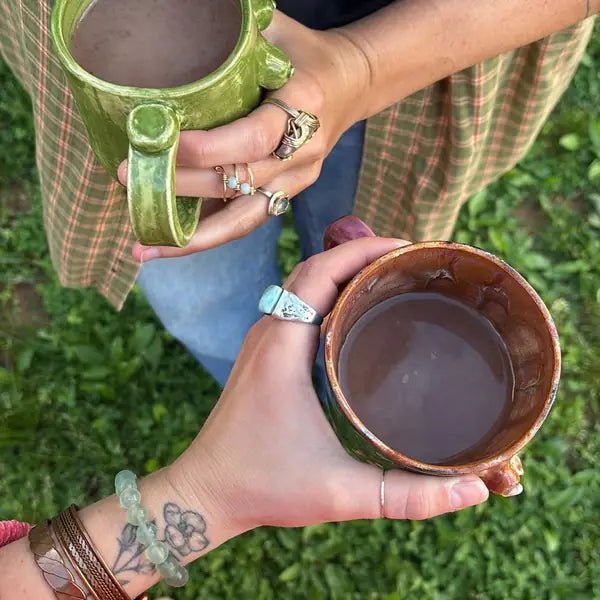 Two people outdoors sharing mugs of cacao, from Jeannie J.'s review
